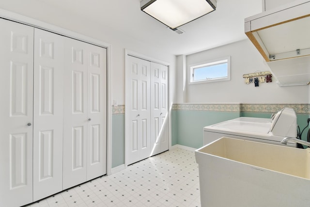 washroom featuring laundry area, attic access, light floors, separate washer and dryer, and a sink