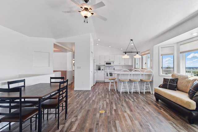 dining area featuring baseboards, ceiling fan, vaulted ceiling, and dark wood-style floors