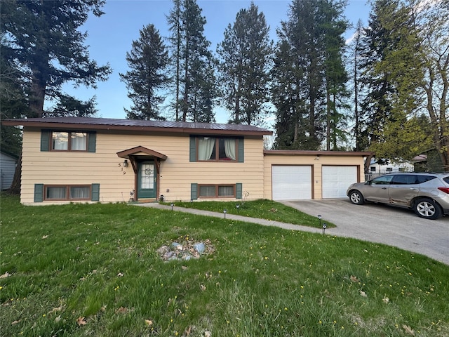 bi-level home with a garage, a front lawn, driveway, and metal roof