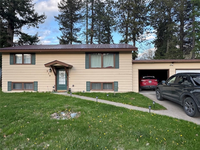 split foyer home with concrete driveway, metal roof, a front yard, and a garage