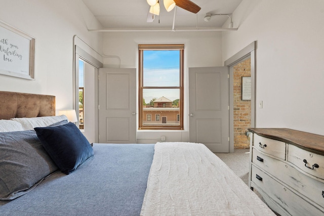 bedroom with ensuite bathroom, ceiling fan, light carpet, and multiple windows