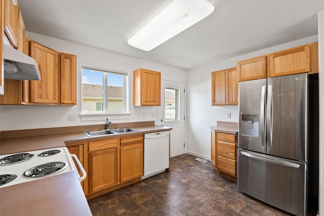 kitchen featuring baseboards, a sink, under cabinet range hood, and white appliances