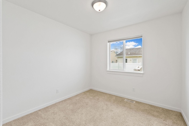 empty room featuring baseboards, carpet flooring, and visible vents