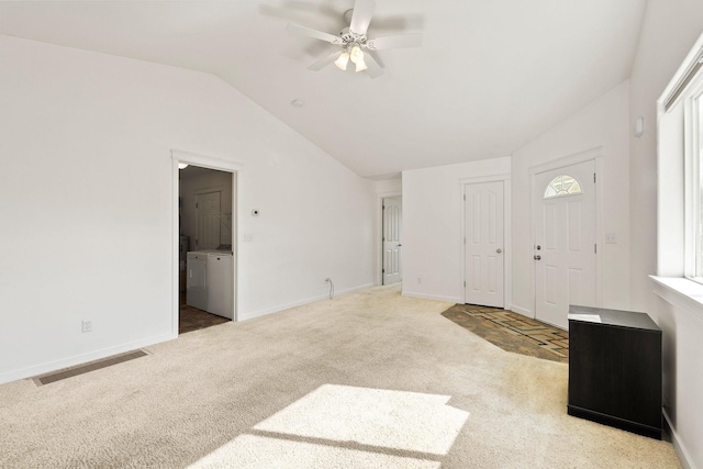 foyer entrance with visible vents, washing machine and clothes dryer, a ceiling fan, carpet, and vaulted ceiling