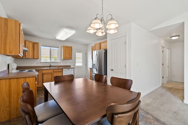 dining room with baseboards, a chandelier, and light carpet
