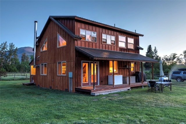 85 Martin Ln, Florence, MT 59833 - rear view of property with board and batten siding, metal roof, a mountain view, and a porch