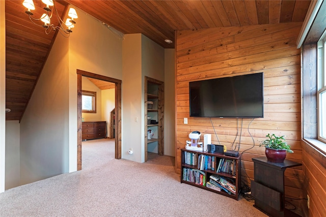 carpeted living area with wood walls, an inviting chandelier, wood ceiling, and vaulted ceiling