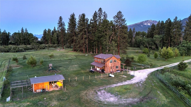 surrounding community with a view of trees, fence, a mountain view, and an outdoor structure