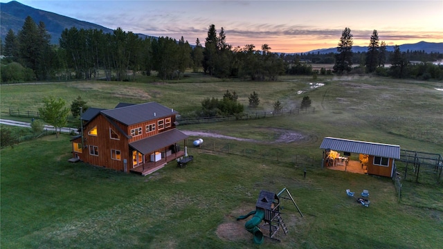 aerial view at dusk featuring a mountain view and a rural view
