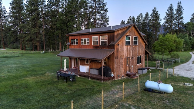 rear view of property featuring a yard, board and batten siding, and metal roof