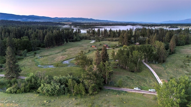 aerial view at dusk featuring a water and mountain view