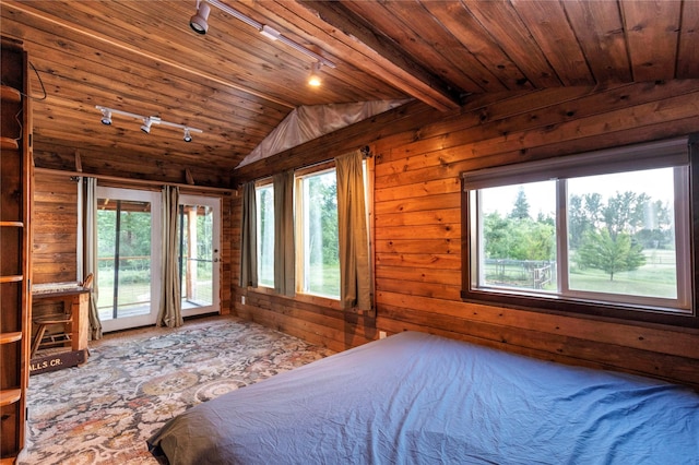 bedroom with track lighting, wood walls, wood ceiling, and access to exterior