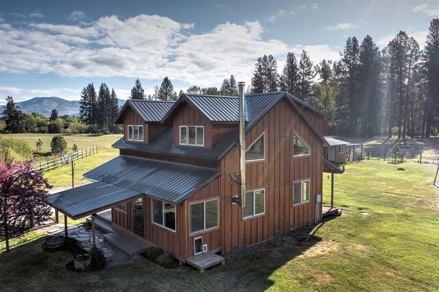 85 Martin Ln, Florence, MT 59833 - rear view of house with board and batten siding, metal roof, and a mountain view