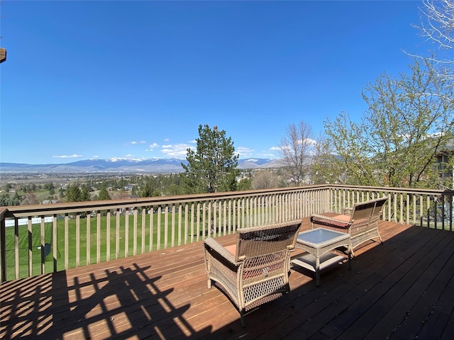 deck featuring a lawn and a mountain view