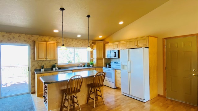 kitchen with light brown cabinetry, a kitchen island, white appliances, light wood-style floors, and a sink