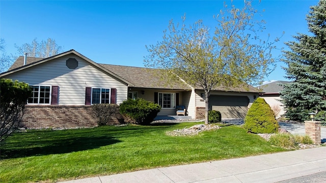 single story home with brick siding, a garage, and a front yard