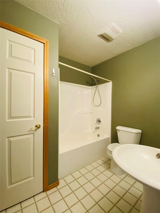 bathroom featuring shower / bathtub combination, toilet, a textured ceiling, and visible vents