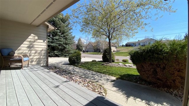 deck featuring a residential view and a yard