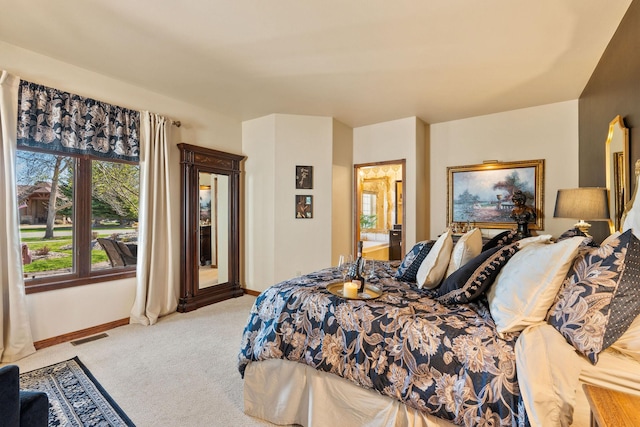 bedroom featuring baseboards, visible vents, connected bathroom, and light colored carpet