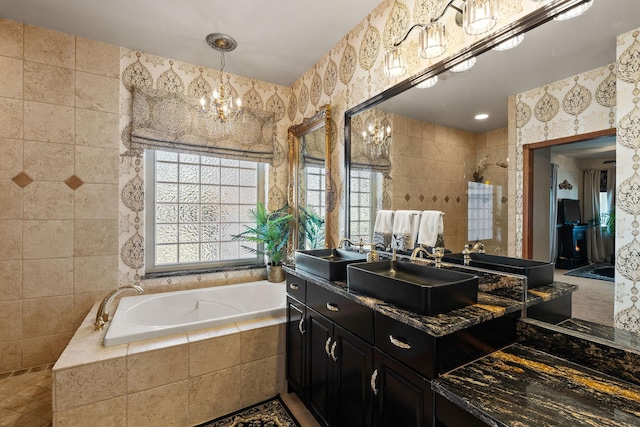 full bathroom featuring an inviting chandelier, a bath, a tile shower, and tile walls
