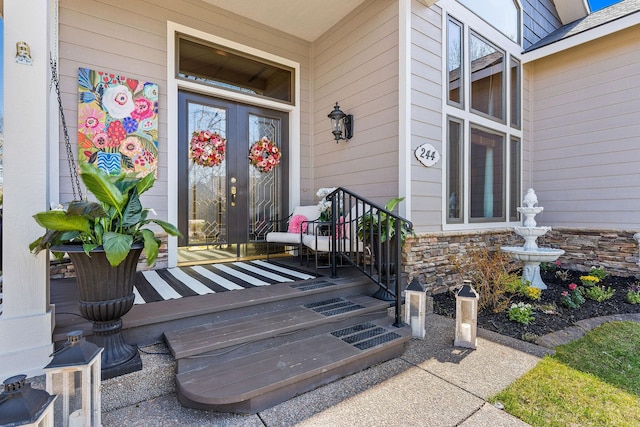 doorway to property featuring a porch and stone siding