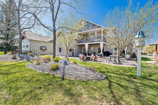 rear view of property featuring a yard, a patio, and a balcony