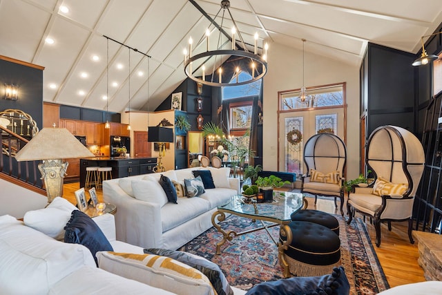 living area with light wood-style floors, high vaulted ceiling, recessed lighting, and a chandelier