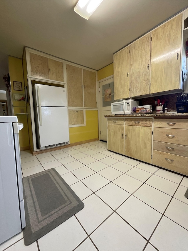 kitchen featuring white appliances and light tile patterned flooring