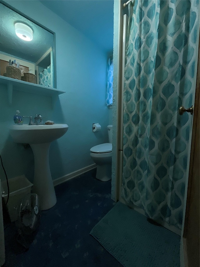 bathroom with a sink, a shower with shower curtain, and toilet