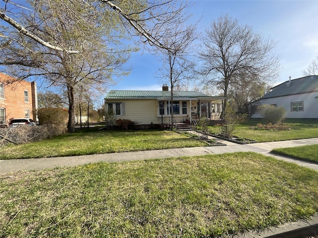 5 W 1st St, Whitehall, MT 59759 - view of front of property featuring a chimney, a front lawn, covered porch, and metal roof