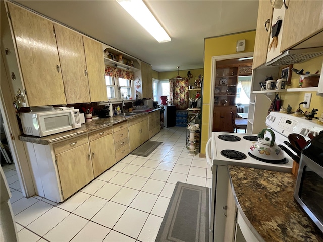 kitchen featuring open shelves, dark countertops, a sink, white appliances, and light tile patterned floors