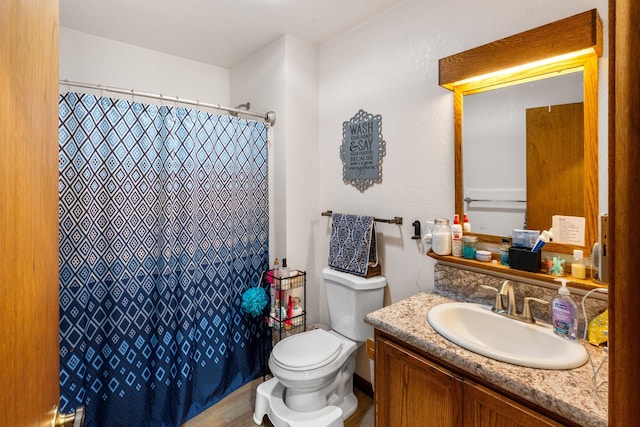 bathroom with vanity, curtained shower, and toilet