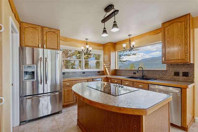 kitchen featuring a center island, a sink, a chandelier, stainless steel appliances, and light tile patterned flooring