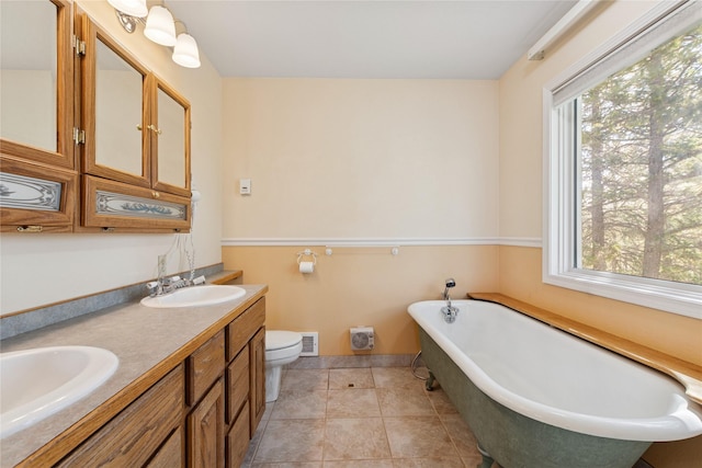 bathroom featuring visible vents, a sink, toilet, and a soaking tub