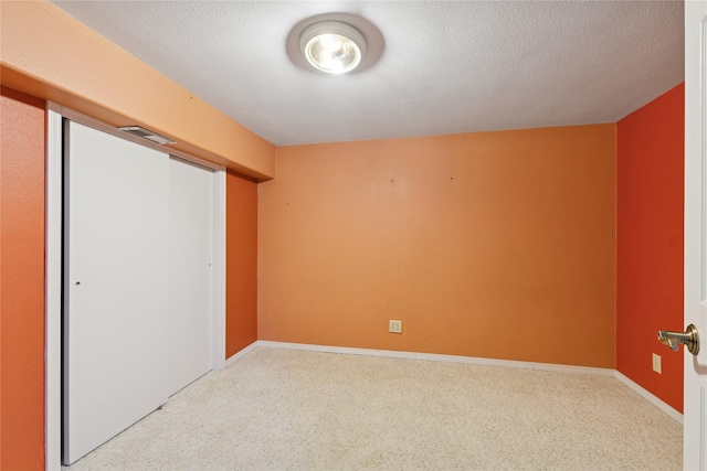 unfurnished bedroom with baseboards, a closet, a textured ceiling, and visible vents