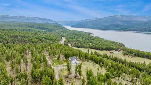 aerial view with a water and mountain view and a forest view
