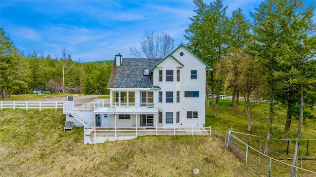 back of property featuring a wooden deck, a chimney, cooling unit, a yard, and fence private yard