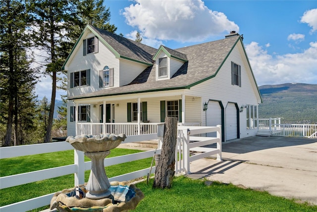 view of front of home featuring a garage, a front lawn, fence, covered porch, and driveway