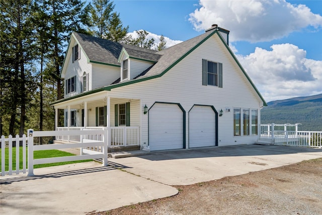 view of front of house featuring a garage, fence, a shingled roof, a porch, and driveway