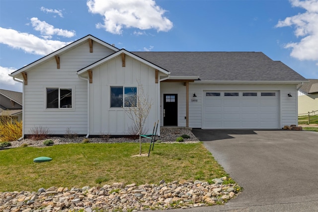5498 Thimbleberry Loop, Helena, MT 59602 - ranch-style house with board and batten siding, an attached garage, a front yard, and aphalt driveway