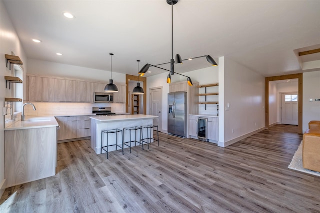5498 Thimbleberry Loop, Helena, MT 59602 - kitchen featuring a kitchen bar, light brown cabinetry, appliances with stainless steel finishes, open shelves, and a center island