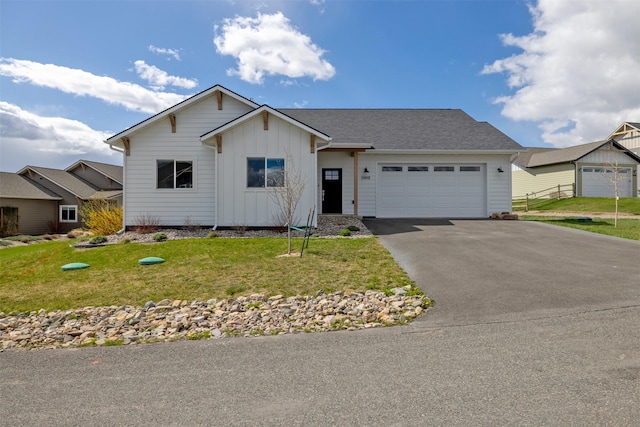 5498 Thimbleberry Loop, Helena, MT 59602 - ranch-style house featuring board and batten siding, an attached garage, a front yard, and aphalt driveway