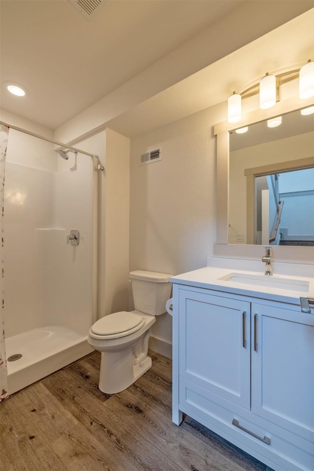 5498 Thimbleberry Loop, Helena, MT 59602 - full bath featuring vanity, toilet, wood finished floors, visible vents, and a stall shower