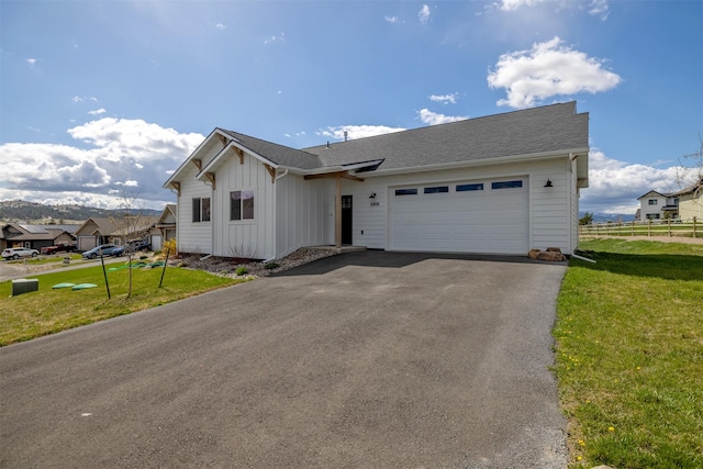 5498 Thimbleberry Loop, Helena, MT 59602 - view of front of house featuring a garage, board and batten siding, fence, and a front yard