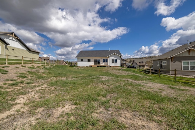 5498 Thimbleberry Loop, Helena, MT 59602 - back of property with board and batten siding, a lawn, fence, and a wooden deck