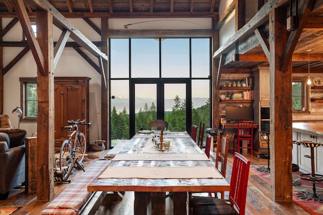 dining space featuring beamed ceiling, a mountain view, french doors, and hardwood / wood-style floors