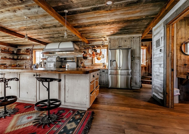 kitchen featuring wall chimney range hood, dark wood-style flooring, wood ceiling, and stainless steel fridge with ice dispenser