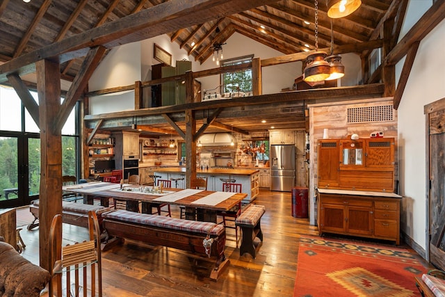 dining room with high vaulted ceiling, visible vents, beam ceiling, and hardwood / wood-style floors