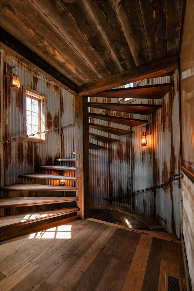 miscellaneous room with visible vents, stairs, wooden walls, hardwood / wood-style flooring, and wooden ceiling