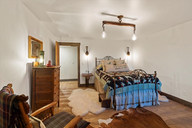 bedroom with baseboards and wood finished floors